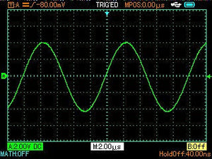 UNI-T UTD1102C 100 MHz 2-Channel Handheld Oscilloscope – 7.5 Kpts, 500MSA/S - displaying a green sine wave on its digital screen with a 2.00µs time base setting.