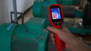 UNI-T UTI712S Cost-effective Thermal Camera – 120×90, -20°C to 400°C, ≤60MK - held in a hand, showing a red casing, buttons, and a digital display with a thermal heat map of a green motor.