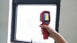 UNI-T UTI712S Cost-effective Thermal Camera – 120×90, -20°C to 400°C, ≤60MK - held in a hand, featuring a red casing, a screen displaying a thermal heat map, and navigation buttons below the display.