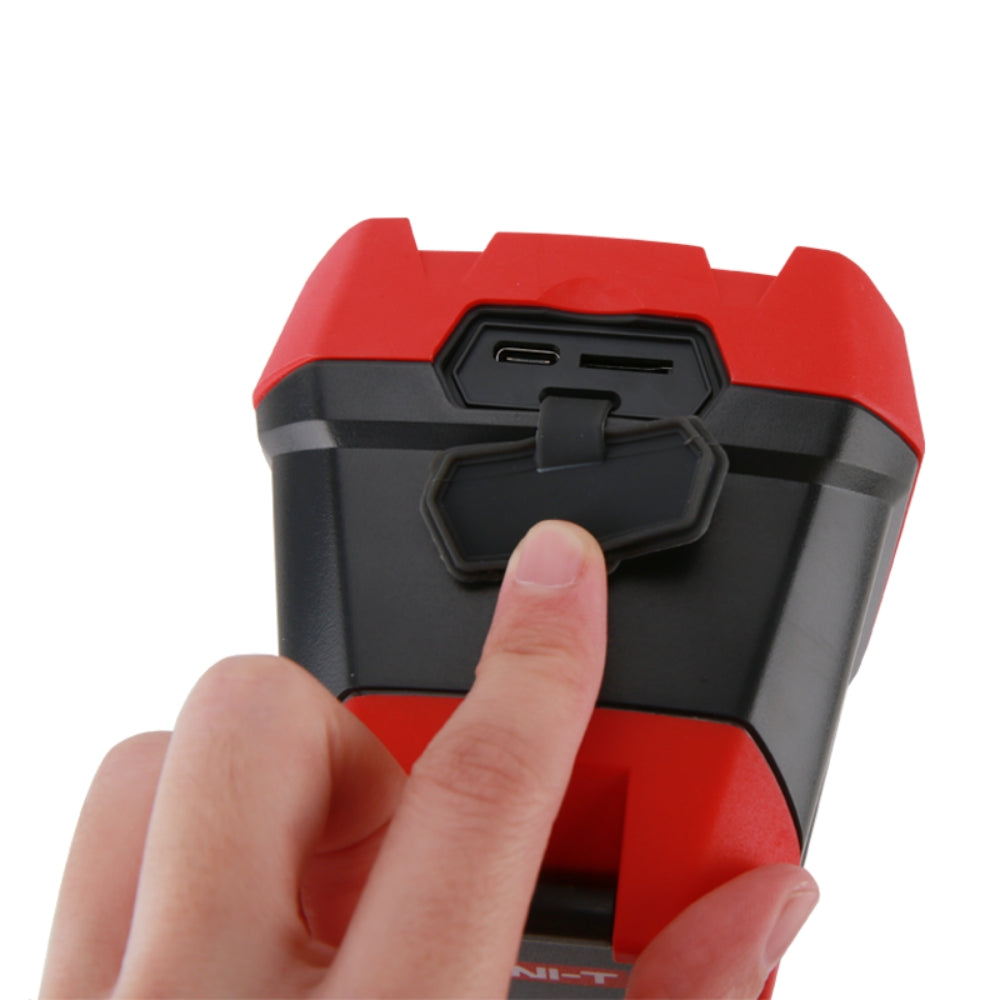 UNI-T UTI720E Enhanced Thermal Camera – 256×192, -20°C to 550°C, ≤50MK - shown in a close-up view of a hand opening the rubber port cover to reveal a USB-C port and a microSD card slot.