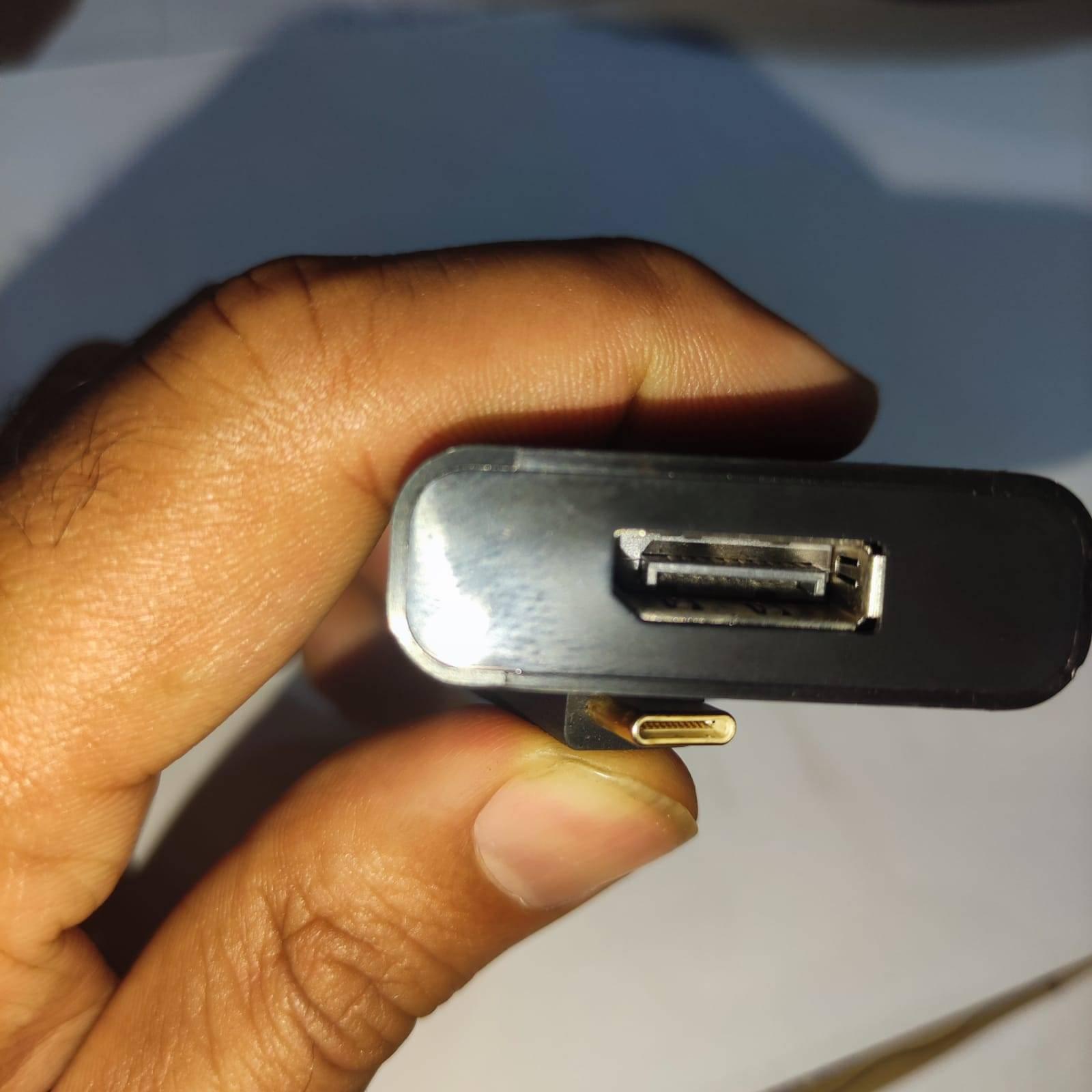 USB C TO DP USB C TO Display Port Adaptor - shown in a close-up, featuring a black rectangular housing with a DisplayPort female port and a USB-C connector.
