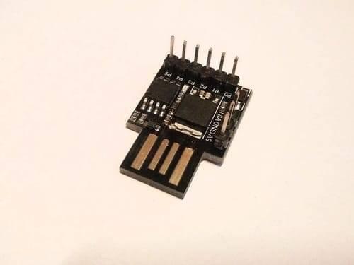 USB Digispark ATTINY85 Developing Board - shown as a black circuit board with a USB connector, six header pins, and labels for 5V, GND, VIN, P0, P1, P2, P3, P4, P5.