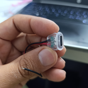 USB Type-C Oval LED Female Socket with Wires for Arduino Pakistan - hand holding a clear plastic oval USB-C female connector with red and black wires.