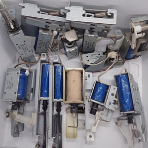 Used 1 Piece DC Solenoid Electromagnet In Mix Shape - collection of various metal 24V DC solenoid actuators with blue coils and attached spring mechanisms.