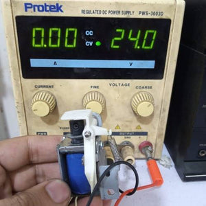 Used 1 Piece DC Solenoid Electromagnet In Mix Shape - connected to a Protek PWS-3003D DC power supply showing 24.0 volts on its digital display.
