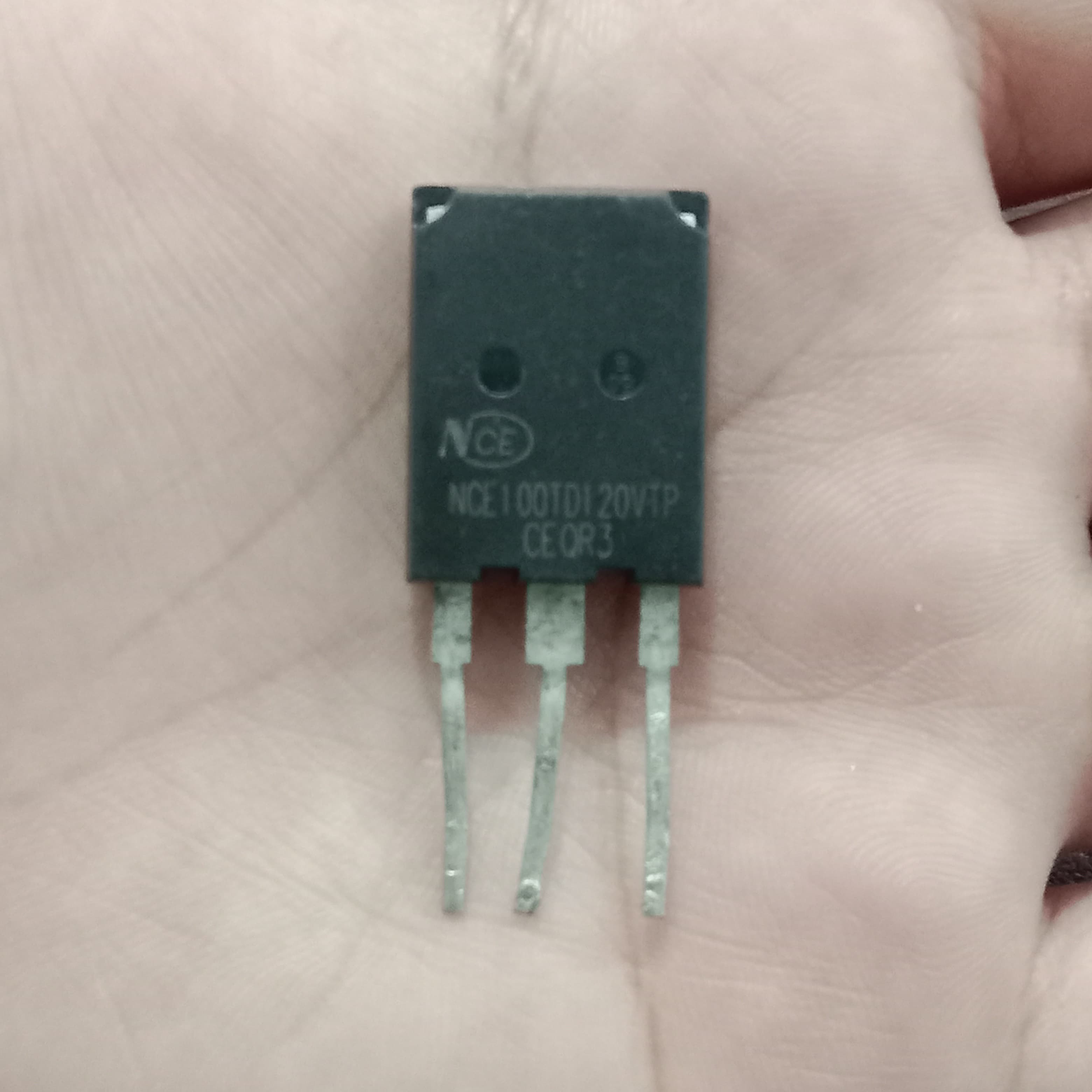 Used 100A NCE 100TD120VTP IGBT - a black three-pin electronic component held in a hand, showing the printed model number and specifications on its front face.