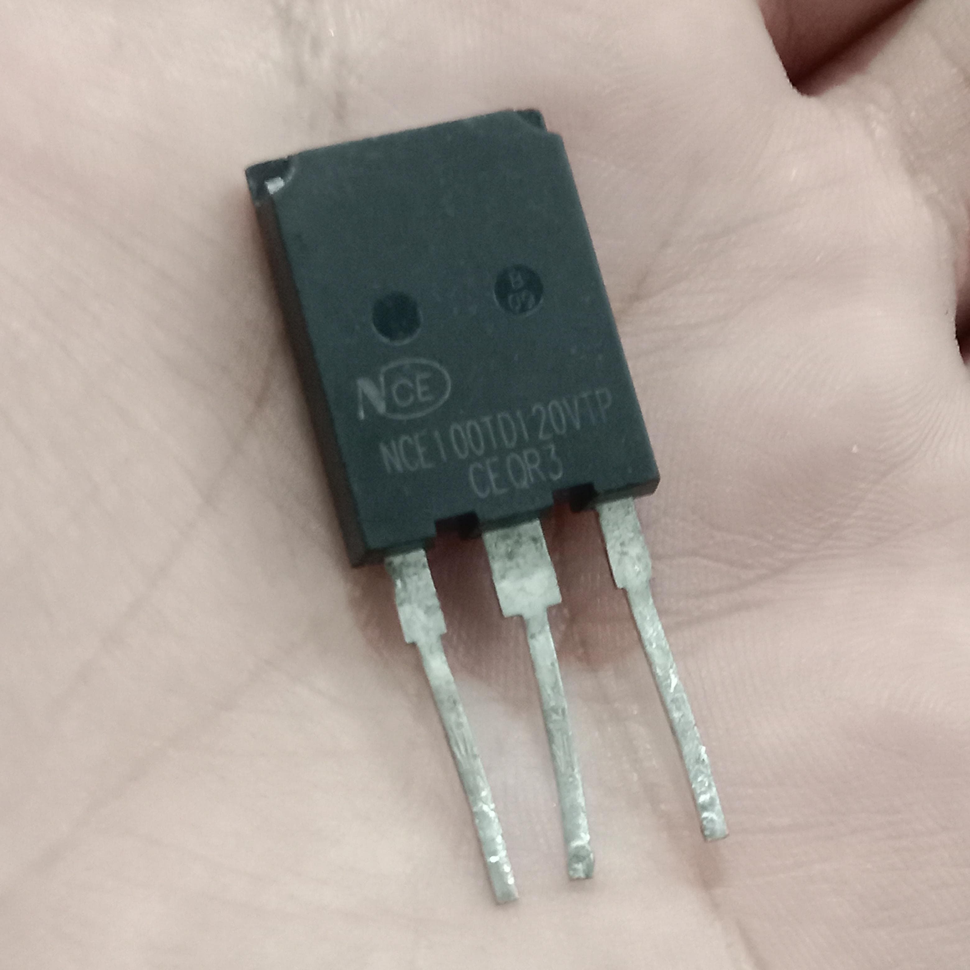 Used 100A NCE 100TD120VTP IGBT - a black, rectangular three-pin electronic component held in a hand, showing the printed model number on its front surface.