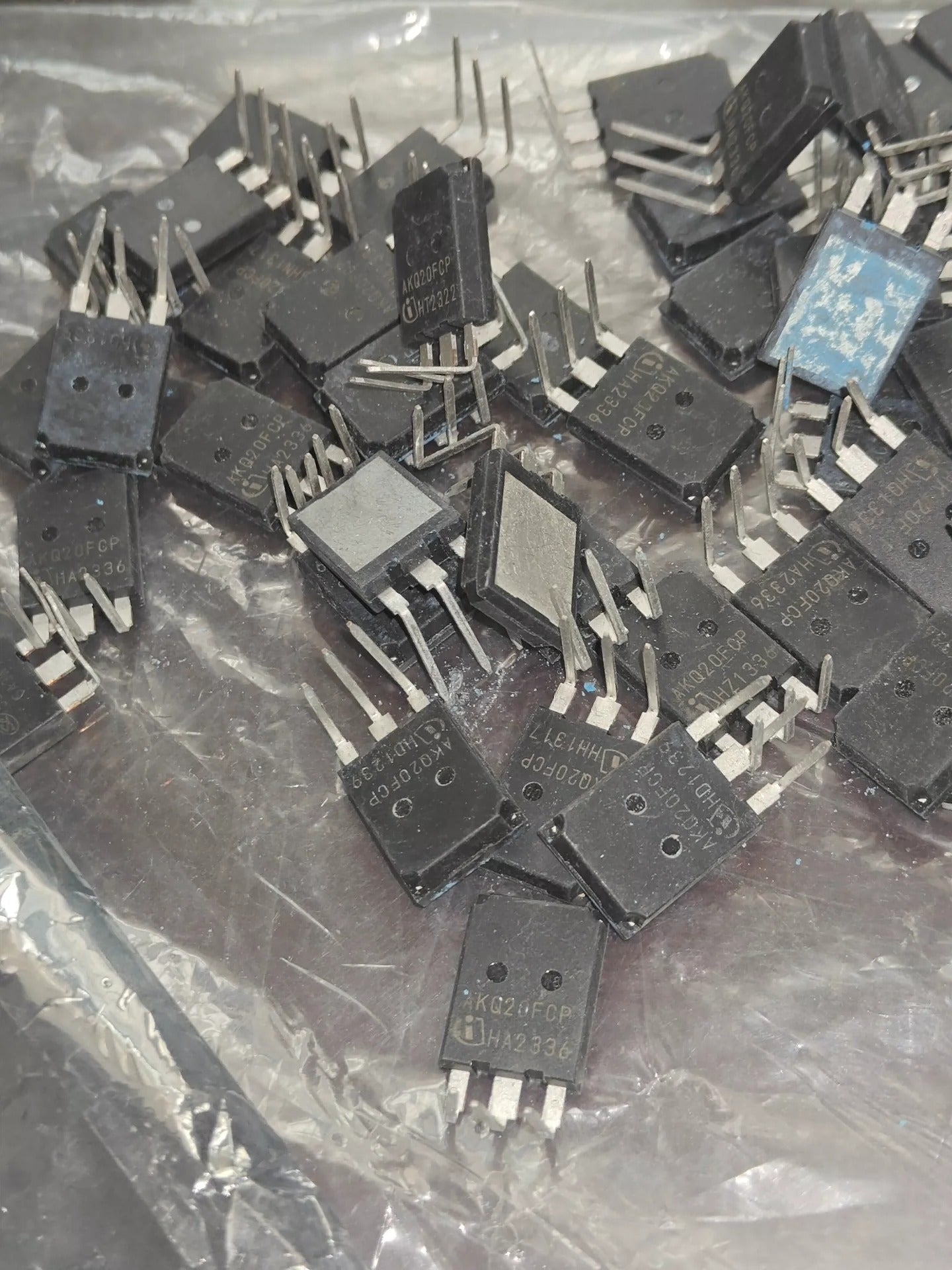 Used 200A 750V AKQ20FCP IGBT with Diode-Digilog.pk - a pile of black, three-pin electronic components inside a clear plastic bag.