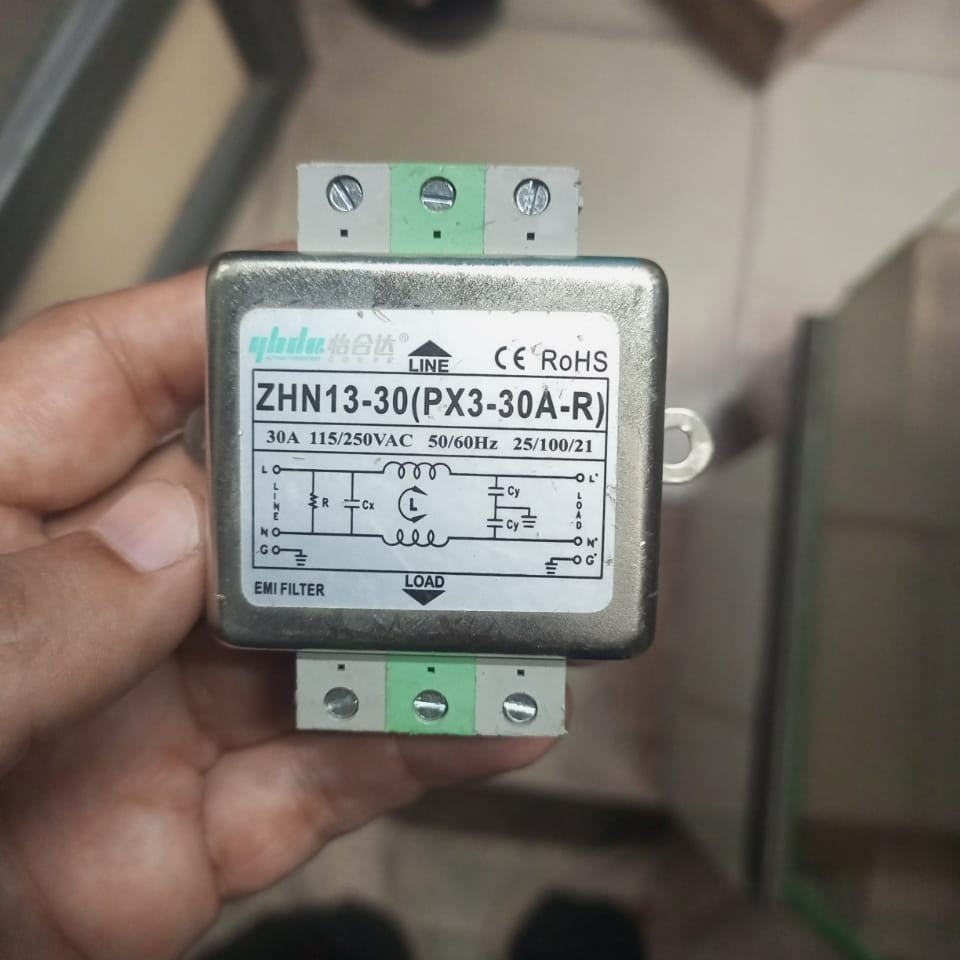 USED 30A EMI Noise Filter - held in a hand, showing a silver metal rectangular casing with a label detailing the ZHN13-30 model and wiring diagram.