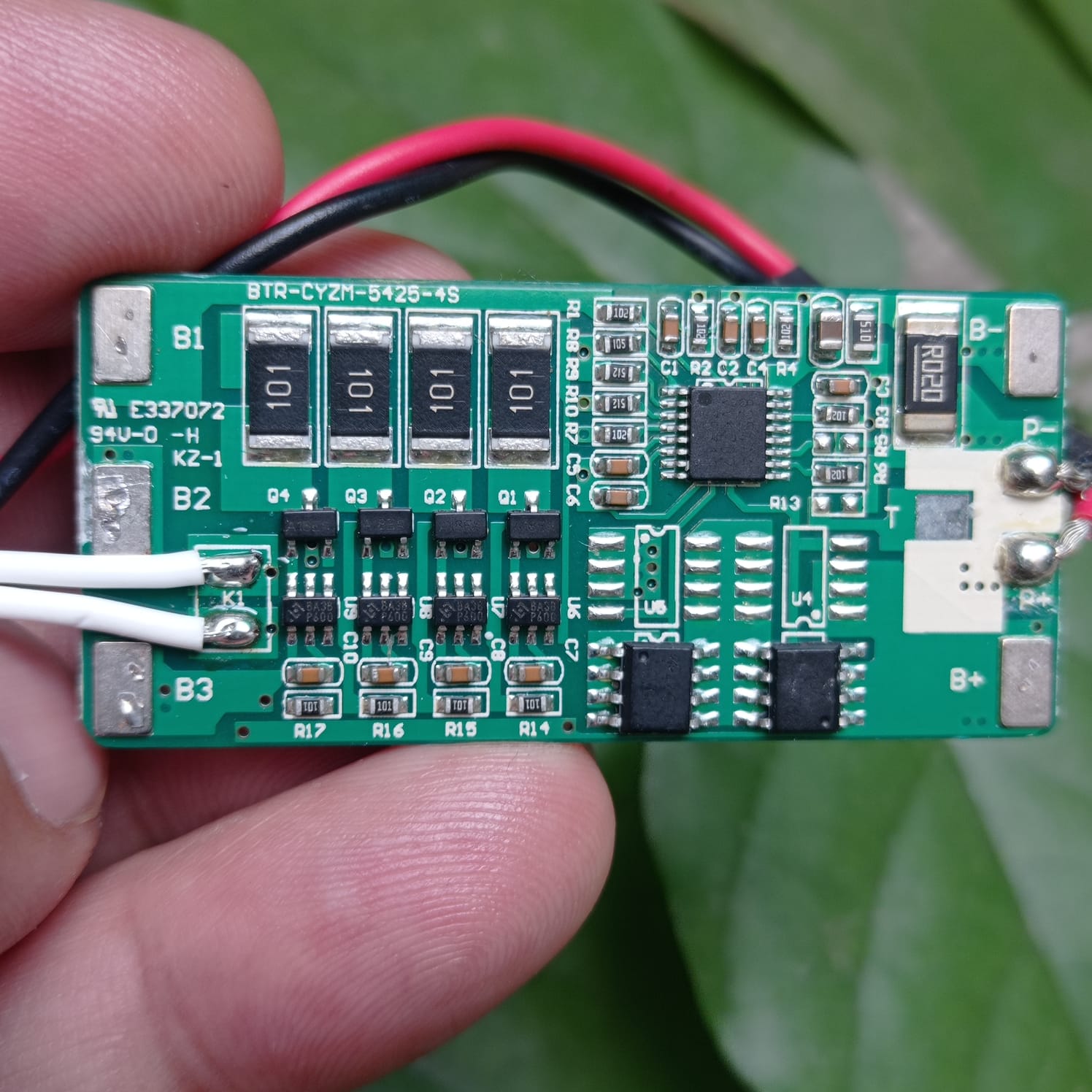 Used 4s 10A BMS With Temperature Sensor And Connector Btr-cyzm-5425-4s - green rectangular circuit board held by fingers with attached wires and ports.