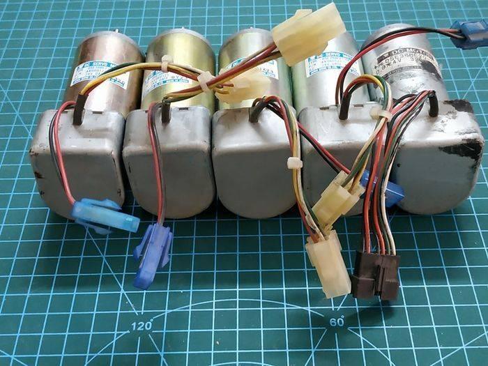 Used DC Servo Motor With Encoder High Speed 24V DC DSE38BE27-001IN Pakistan - five silver cylindrical motors with attached grey gearboxes, wiring harnesses, and plastic connectors.
