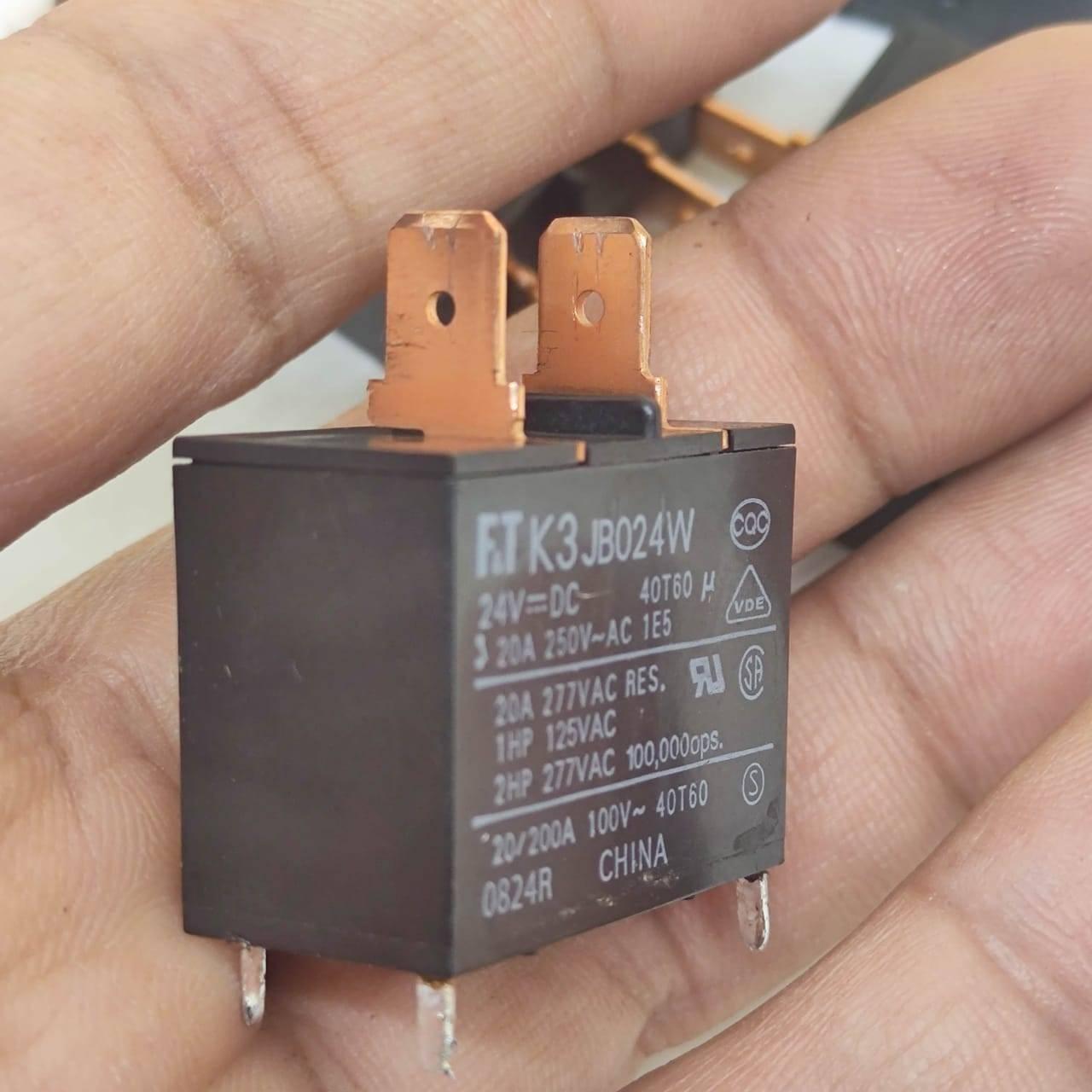 USED Fujitsu Japan JB024W 24V 20A Relay Switch High Current Relay POWER RELAY - a black rectangular electronic component with two copper spade terminals held in a hand.