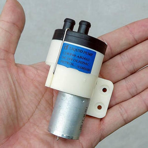 Used High Pressure Liquid Water Pump 370 DC 12V-24V - a white plastic pump head with two nozzles and a silver cylindrical motor.