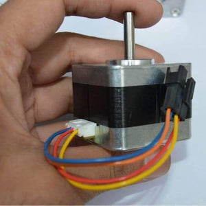 USED Minebea NEMA 17 Stepper Motor For 3d Printer & CNC - a silver and black square motor with a metal shaft held in a hand, featuring an attached white connector and wires.