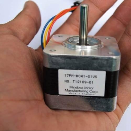 USED Minebea NEMA 17 Stepper Motor For 3d Printer & CNC - a silver, square-shaped motor with a central metal shaft and a label reading 17PM-K041-G1VS, held in a hand.