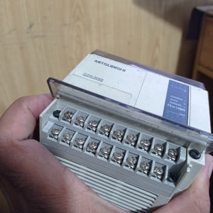 Used Mitsubishi PLC Fx1n-14MR-ES/UL - a grey rectangular industrial controller held in a hand, showing front screw terminals and status indicator lights.