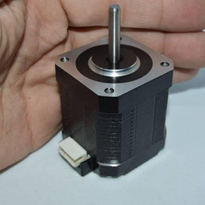 Used NEMA 17 4.2 Kg-cm Stepper Motor For CNC And 3d Printer - a black square motor with a silver shaft and a white electrical connector, held in a hand.
