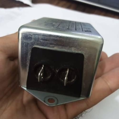 Used Noise Filter EMI Filter Anti-Interference Noise Signal Filtration Single Phase Mains Filter 125V 250V - a close-up of the silver metal casing and the black connector panel with two metal spade terminals held in a hand.