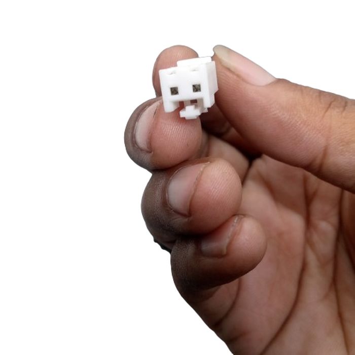 Used Power Supply Adapter 24V 5A 120W - close-up of a small white plastic two-pin electrical connector held between fingers.