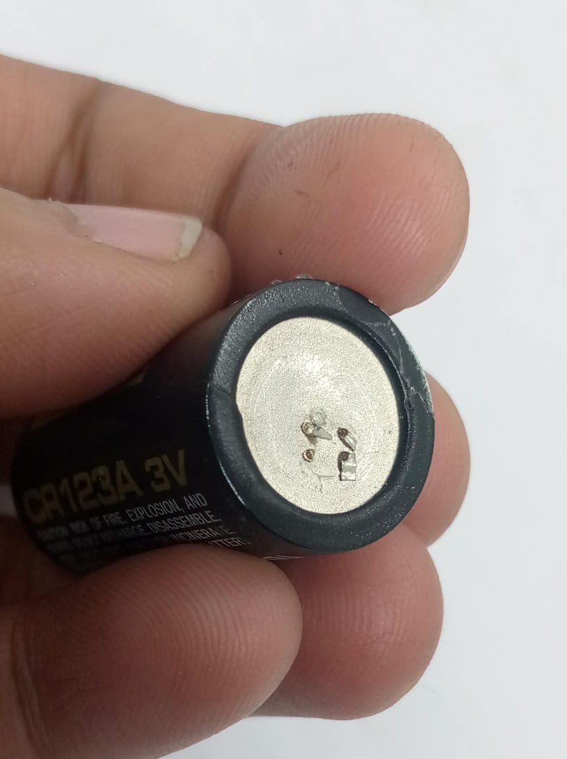 USED Product Panasonic Industrial CR123A Lithium Battery - a close-up showing the black cylindrical body and the silver top terminal with small spot weld marks.