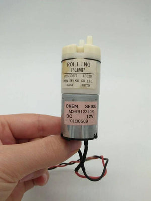 Used Suction Pump 12V DC Water Pump & Air Pump - shown as a cylindrical silver motor attached to a white plastic pump head with two small ports.