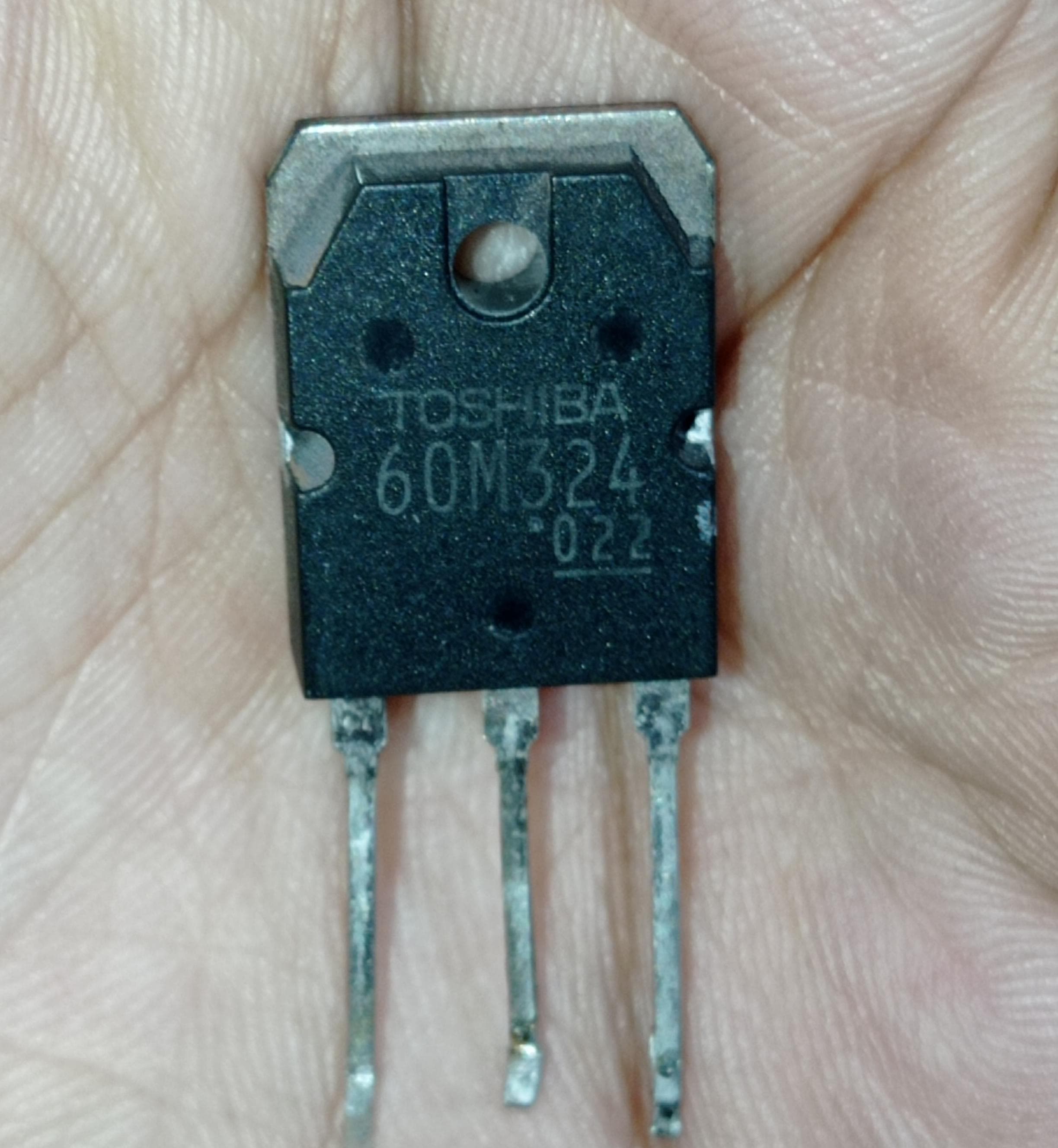 Used Toshiba GT60M324 60M324 IGBT Transistor - a close-up of the black, three-pin electronic component held in a hand with the model number clearly visible.