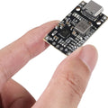 V1342 IP2326 8.4V 12.6V 1.5A LiPo 2s 3s Battery Charger With Balancing Feature With Indicator - a black rectangular circuit board with a USB-C port, held by fingers, showing various electronic components and solder pads.