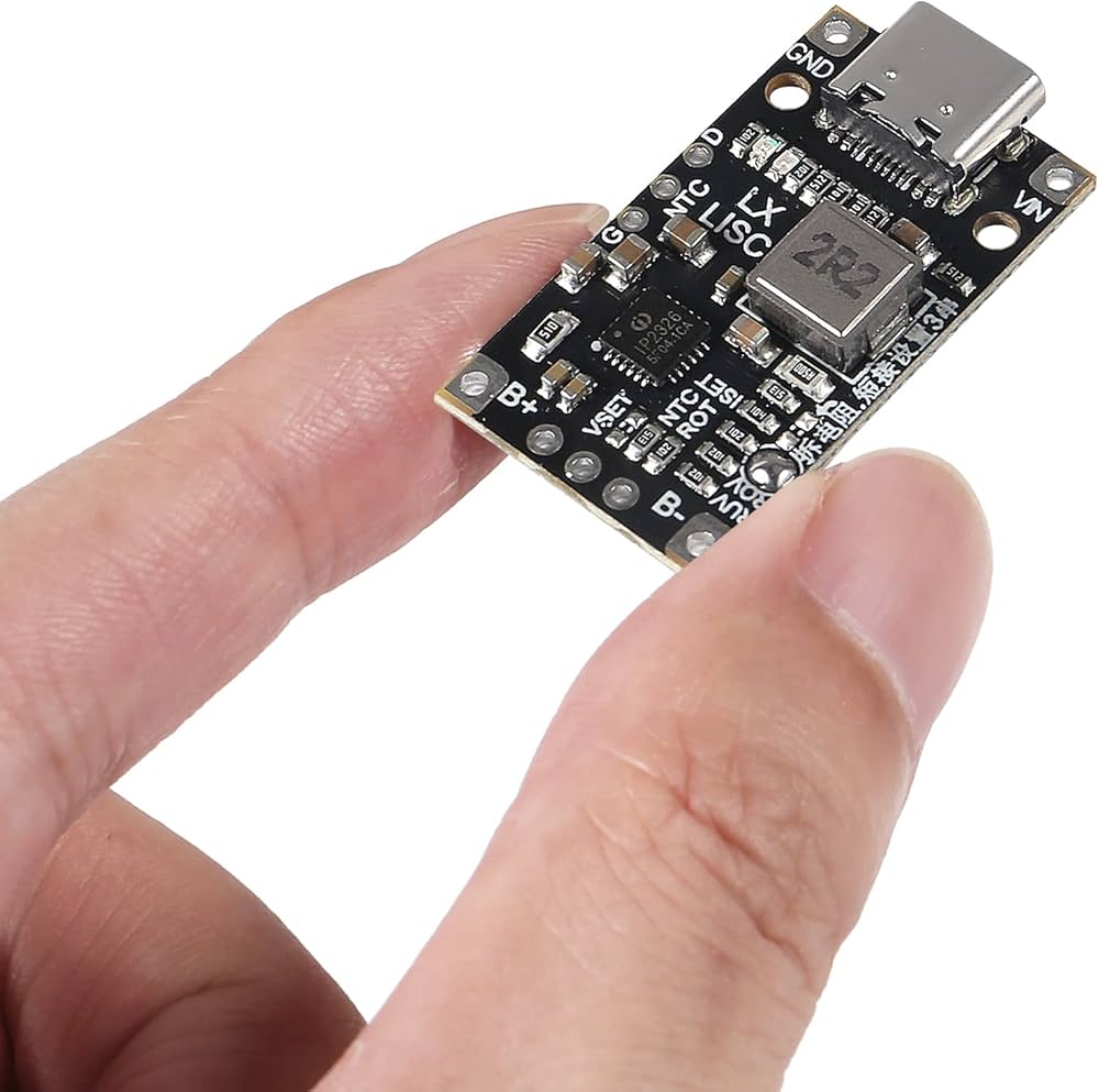 V1342 IP2326 8.4V 12.6V 1.5A LiPo 2s 3s Battery Charger With Balancing Feature With Indicator - a black rectangular circuit board with a USB-C port, held by fingers, showing various electronic components and solder pads.