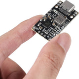 V1342 IP2326 8.4V 12.6V 1.5A LiPo 2s 3s Battery Charger With Balancing Feature With Indicator - a black rectangular circuit board with a USB-C port, held by fingers, showing various electronic components and solder pads.
