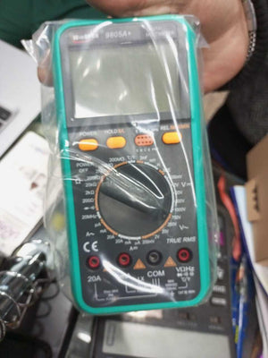 VC9805A+ Digital Multimeter - in green plastic casing, shown inside a clear protective plastic bag with a rotary dial, buttons, and input ports visible.