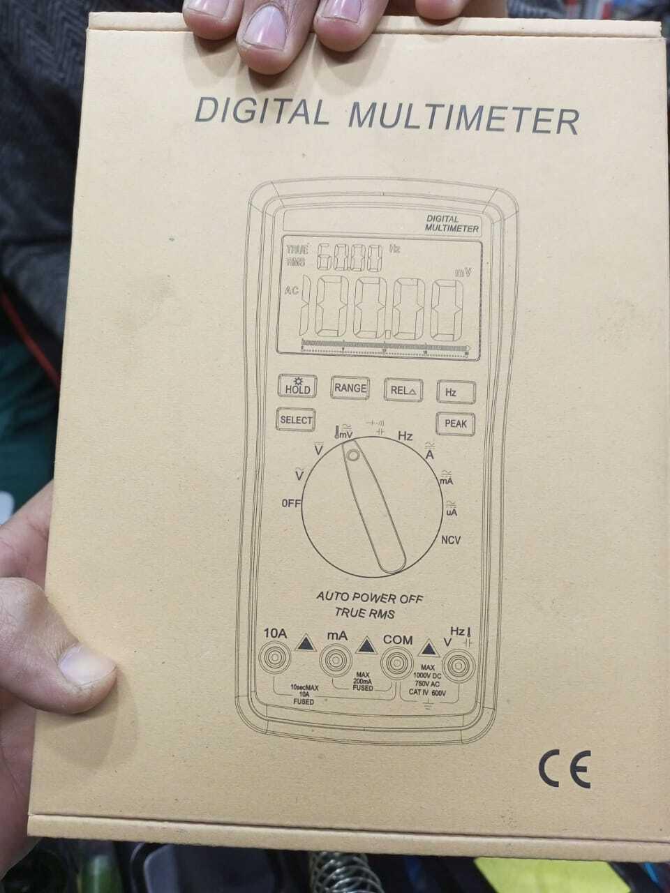 VC9805A+ Digital Multimeter - shown on its beige cardboard packaging, featuring a printed diagram of the device with a display, buttons, and input ports.