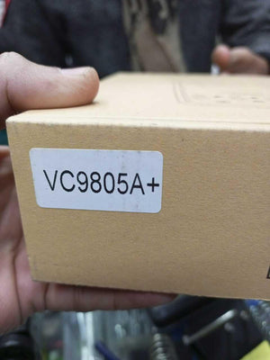 VC9805A+ Digital Multimeter - a close-up of the brown cardboard box with a white label printed with the model name.