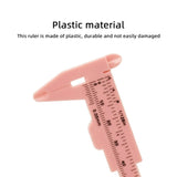 80mm Plastic Vernier Caliper | Dual Scale Mini Measuring Tool - a close-up of a pink plastic sliding measuring tool showing metric and imperial scale markings on its body.