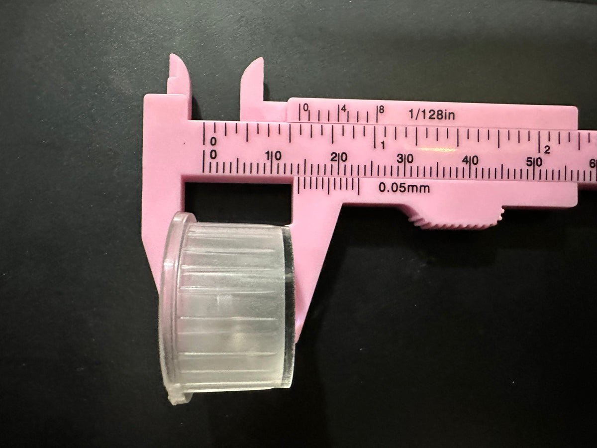 Versatile Waterproof LED Lens 1W/3W 20mm Diameter Smooth surface 15°/30° Beam Options - a clear cylindrical lens being measured by a pink plastic vernier caliper showing a width of 20mm.