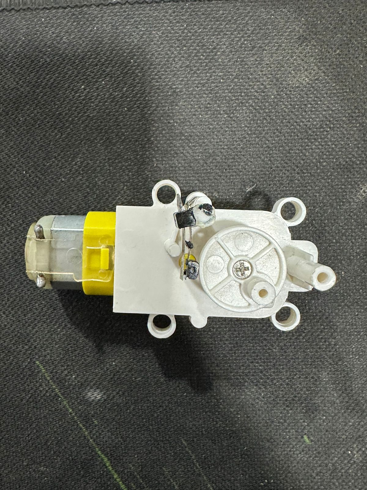 Vertical Motion TT DC Gear Motor with Cam Mechanism – Reciprocating Up-Down Movement Module for DIY Robotics & Automation - a white plastic housing with a yellow-cased motor and a circular rotating cam component.