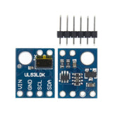 VL53L0X Laser Distance Sensor - shown with two blue circuit boards displaying pins and a separate six-pin header strip on a white background.
