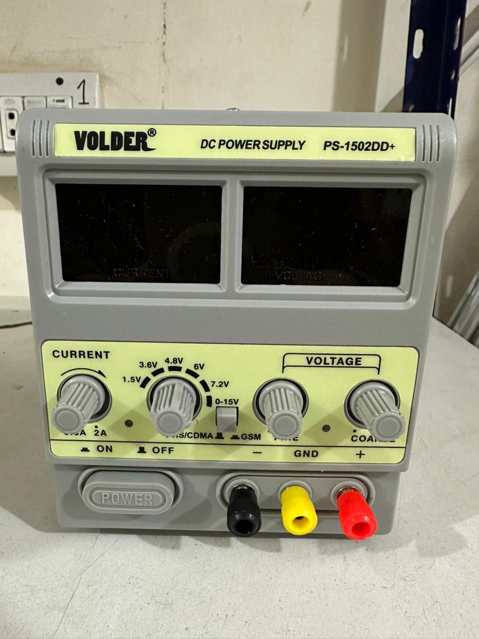 VOLDER 1502DD+ Regulated DC Power Supply - VOLDER PS-1502DD+ DC power supply in a grey casing with two blank digital displays, voltage and current control knobs, and black, yellow, and red terminals.