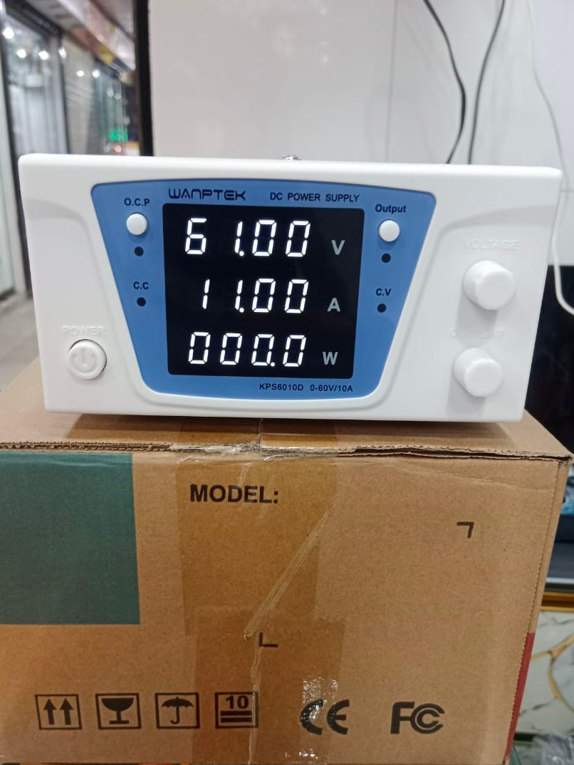 Wanptek KPS6010D DC Power Supply 0-60V 0-10A Adjustable Bench Power Supply - on a cardboard box, showing a white unit with a digital display reading 61.00V, 11.00A, and 000.0W with control knobs.