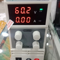 Wanptek KPS605D DC Power Supply 0-60V 0-5A Adjustable Bench Power Supply - a white bench unit with four control knobs, a power switch, two output terminals, and a display reading 60.2V 0.00A.