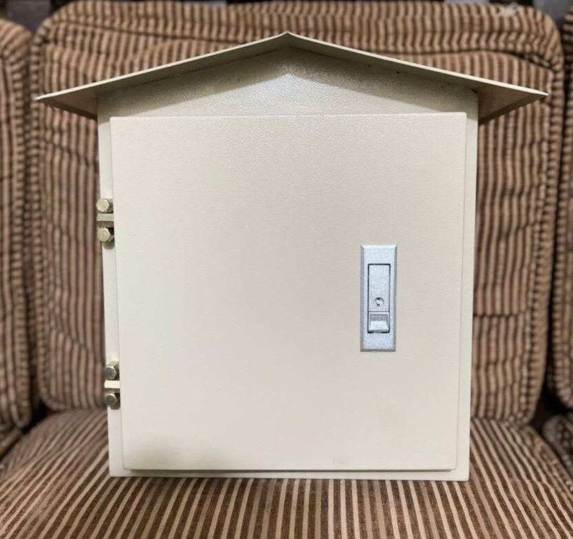 Water Proof Metal Panel Box - a gabled roof, two left-side hinges, and a central locking mechanism on the front door.