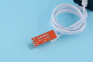 Water Turbidity Sensor - an orange circuit board with three pins labeled VCC, OUT, and GND, connected to a coiled white cable.