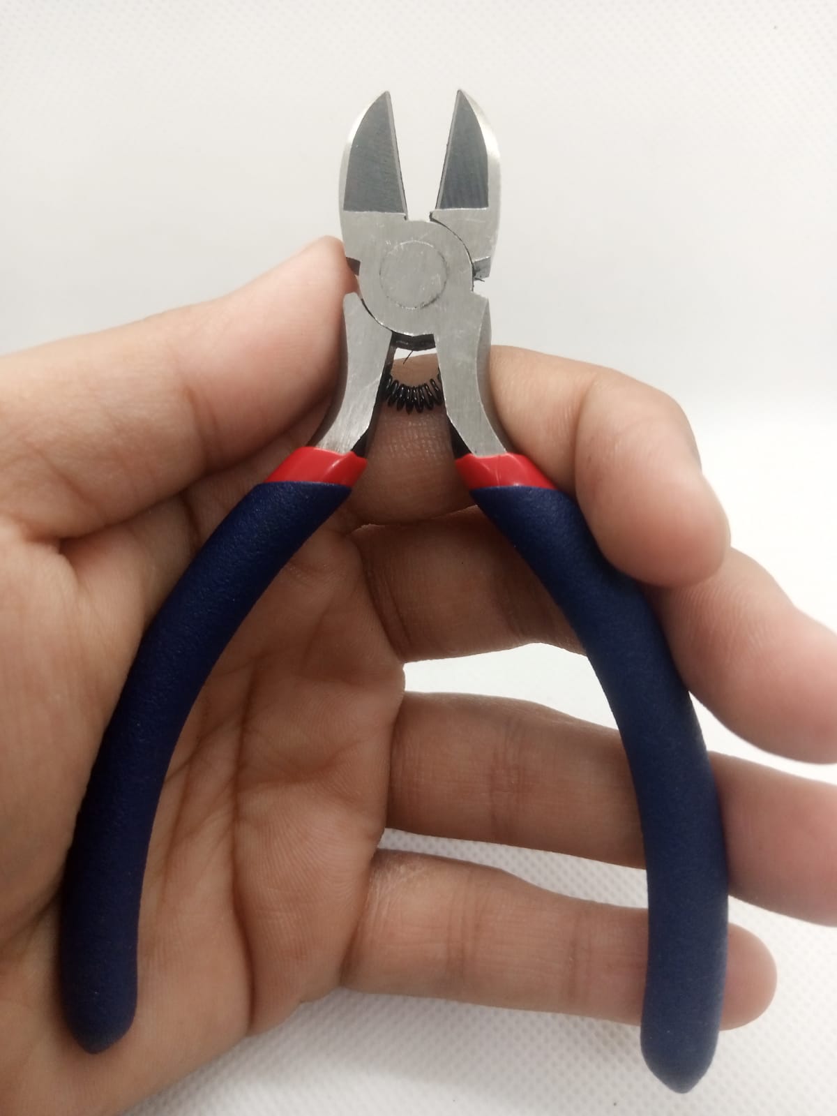 Wire Cutter Cable Cutter With Coil Spring - shown held in a hand, featuring steel blades, a small internal coil spring, and blue handles with red accents.