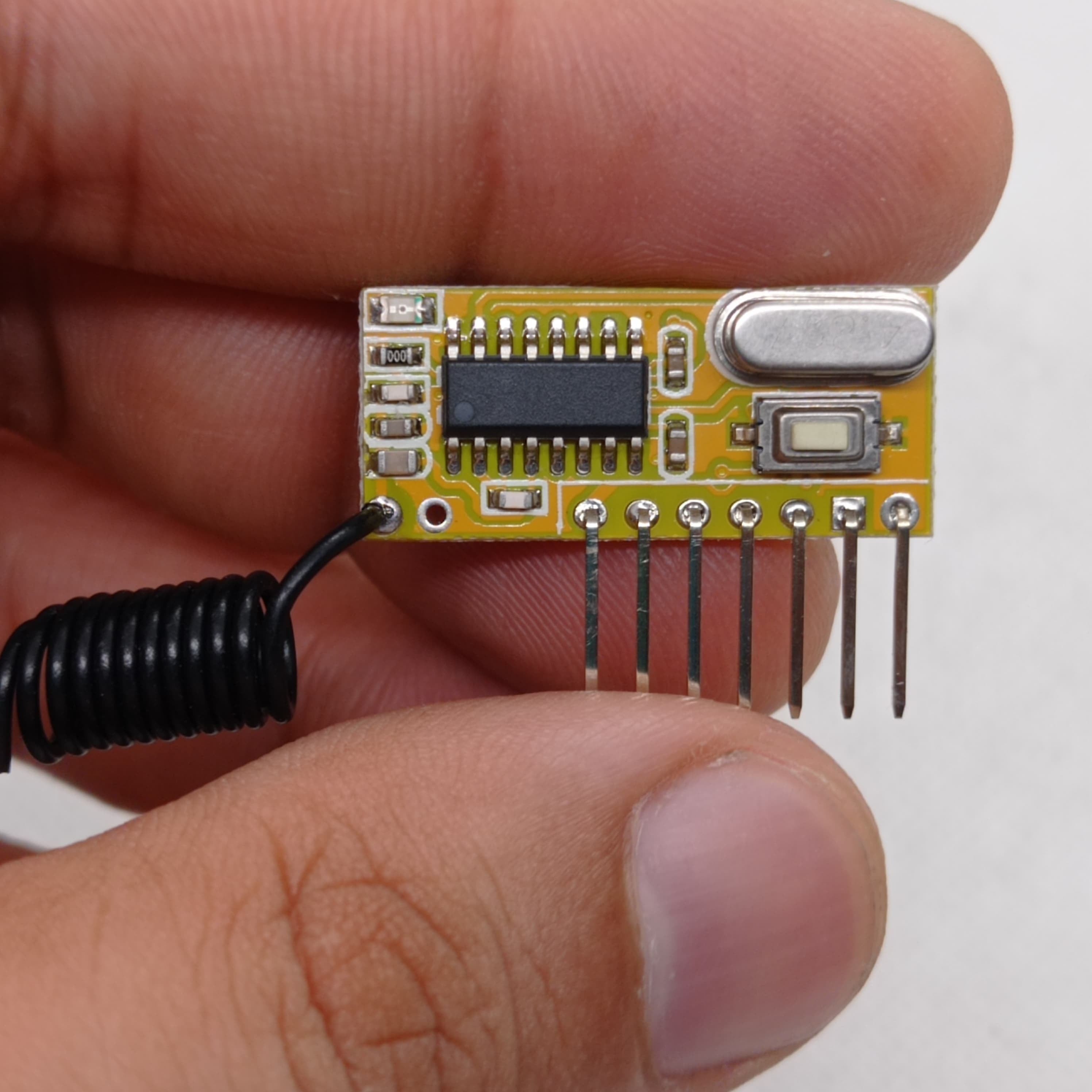 Without Battery 4 Channel Wireless Remote Control Kit RX12 RF Transmitter Receiver Module For Arduino Momentary Type - a yellow circuit board with a black chip, a silver crystal, and a coiled antenna.