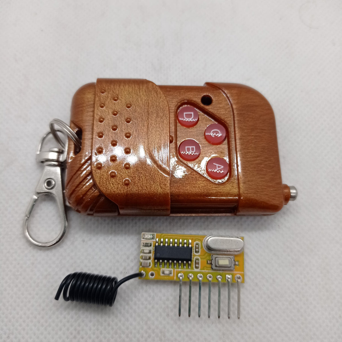 Without Battery 4 Channel Wireless Remote Control Kit RX12 RF Transmitter Receiver Module For Arduino Momentary Type - brown wood-grain four-button remote and a small yellow circuit board with a black coil antenna and six pins.