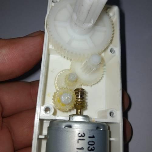 Worm Gear High Torque 12V 5RPM DC Gear Motor - a close-up view of the internal white plastic gear train and brass worm gear connected to a silver DC motor.