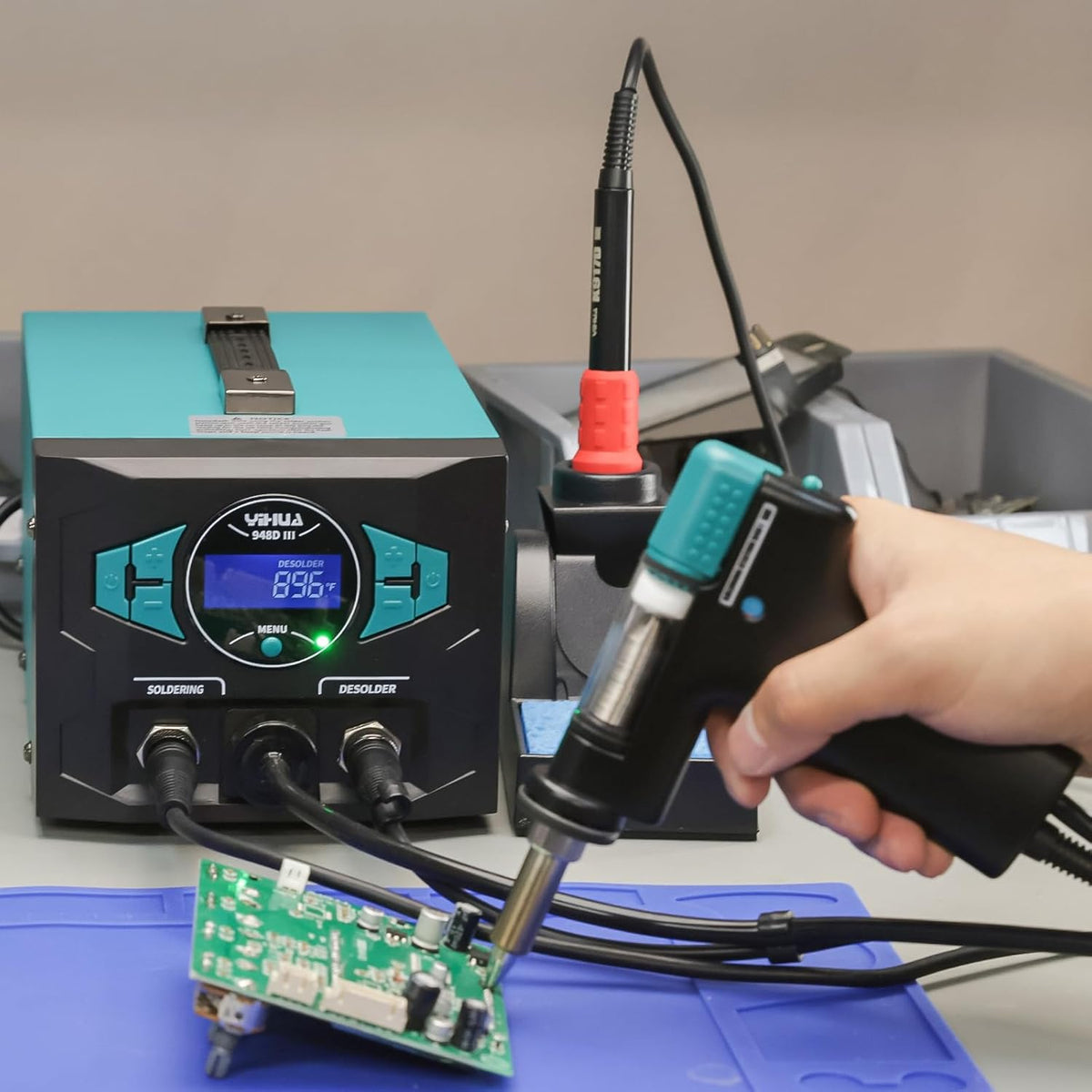 Technician desoldering a PCB with the YIHUA 948D III desoldering gun