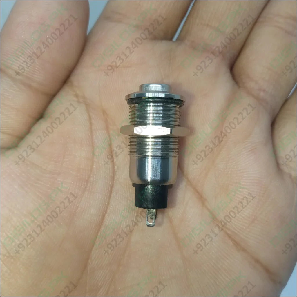 ZLQ-B5V 12mm Waterproof Metal Push ON Push OFF Button Switch With Power Indication - a silver-coloured cylindrical metal button held in a hand with a black base and connector.