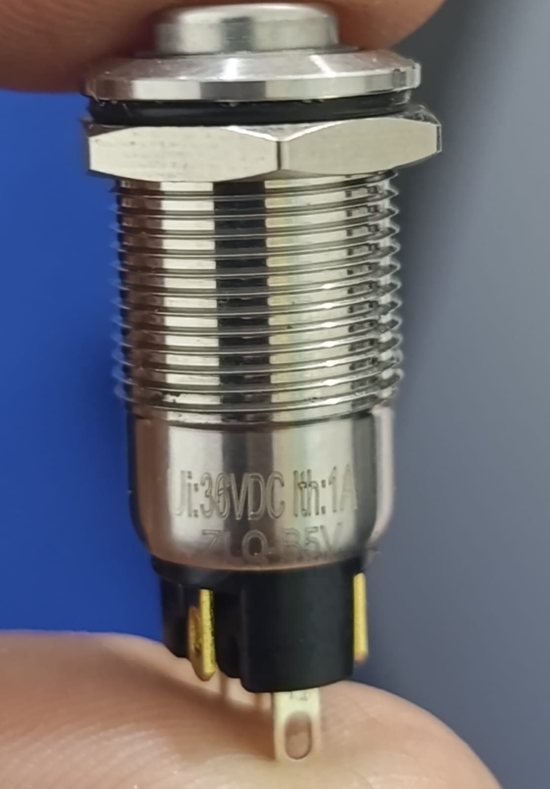 ZLQ-B5V 12mm Waterproof Metal Push ON Push OFF Button Switch With Power Indication - a close-up showing the silver metal cylindrical body, threaded shaft, and three bottom contact pins.